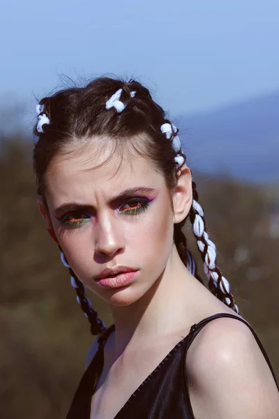 Meisje met modieuze make-up op de blauwe hemelachtergrond. — Stockfoto