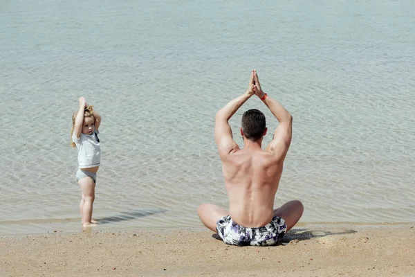 Padre hombre e hijo meditando en pose de yoga —  Fotos de Stock