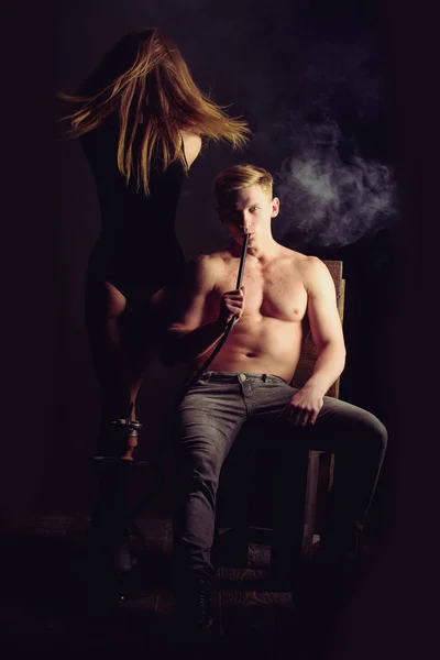 Man smoking hookah with sexy girl — Stock Photo, Image