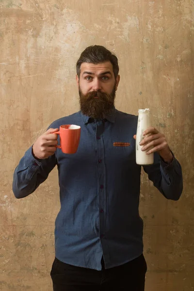 Adam uzun sakal ve sürpriz yüz tutun süt şişesi. — Stok fotoğraf