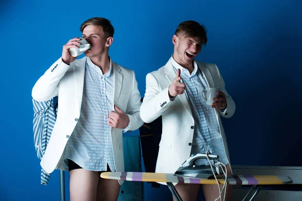 Чоловік п'є з чашки в роздягальні — стокове фото