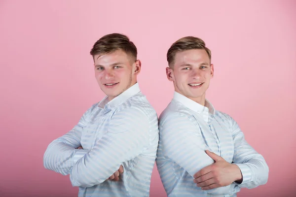 Dois irmãos sorrindo no fundo rosa — Fotografia de Stock