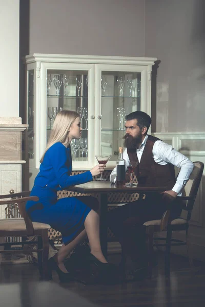 Man en vrouw met blond haar zitten met martini glazen — Stockfoto