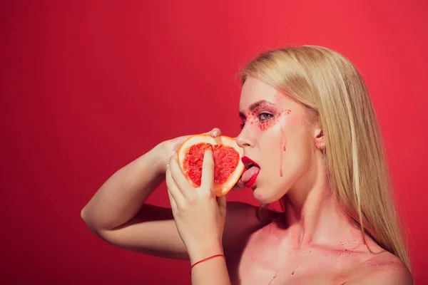 Meisje met creatieve modieuze make-up greep grapefruit, vitamine — Stockfoto