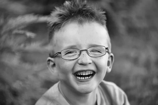 Menino feliz com cabelo nos óculos — Fotografia de Stock