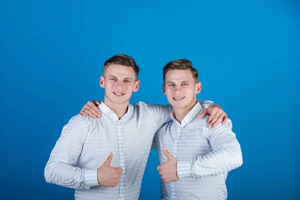 Homens felizes abraçando e mostrando os polegares acima gestos — Fotografia de Stock