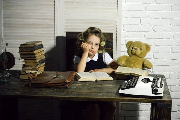 Liten flicka med locktång i hår läsa bok. — Stockfoto