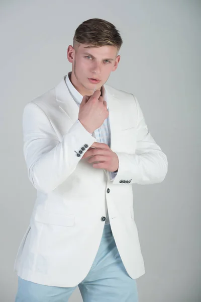 Model poseren in witte jas, gestreepte shirt en blauwe broek — Stockfoto