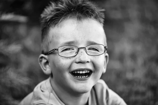 Menino feliz com cabelo nos óculos — Fotografia de Stock