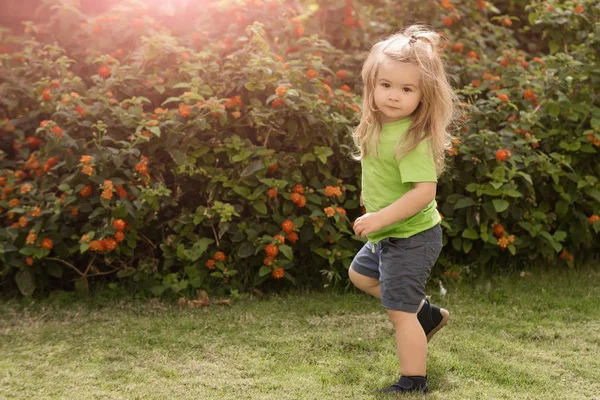 Niño niño con cara linda de pie en una pierna — Foto de Stock