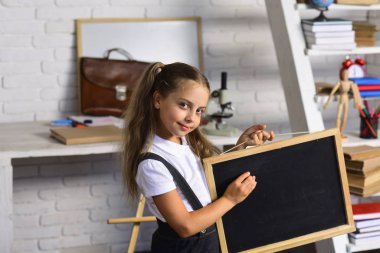 Mutlu yüz ifadesi ile okul Masası yakınındaki kızla malzemeleri