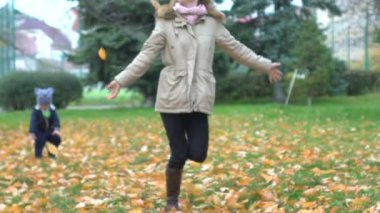 Anne, oğlu Sonbahar oynamak Bahçe parkta bırakır. Sonbahar doğa, açık hava oyunları üzerinde yürümek, çim çalıştırın ve sarı altın varak atmak. Kasım ayında eğlence. Çocukluk ve annelik, Aile mutluluğu