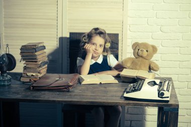 Evrak çantası ve masada daktilo ile çocuk.