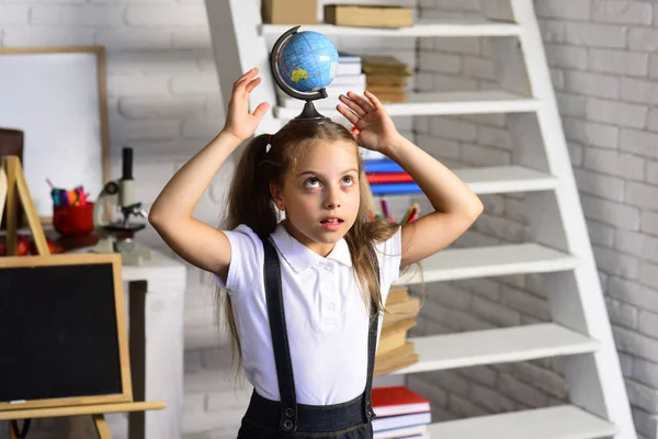 Il ragazzo fa esperimenti. Studentessa tiene globo sulla testa — Foto Stock