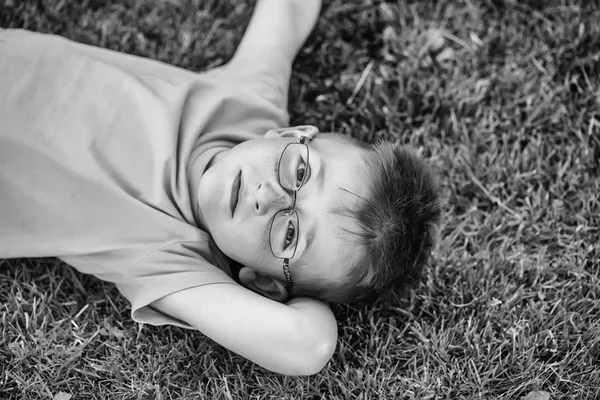 Bambino con i capelli negli occhiali sull'erba — Foto Stock