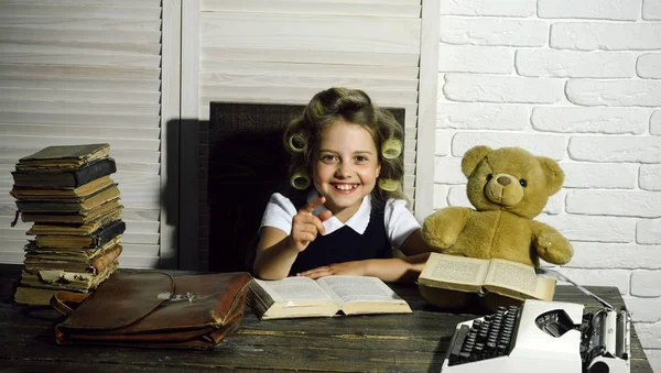 Küçük kız kıvırıcı saç ile kitap okumak.