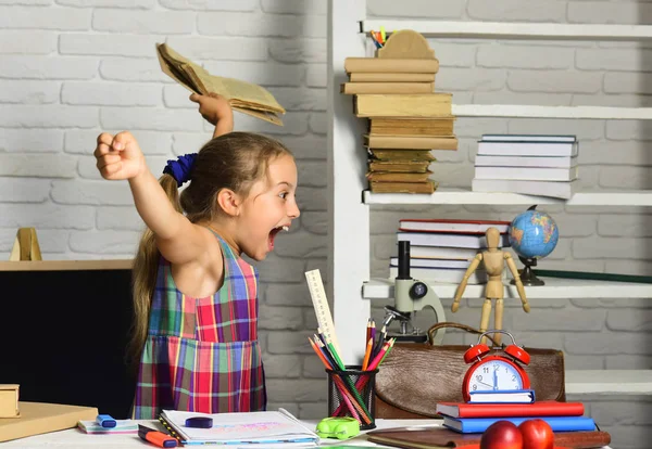 Schoolmeisje met blij gezicht houdt open boek en schreeuwt — Stockfoto