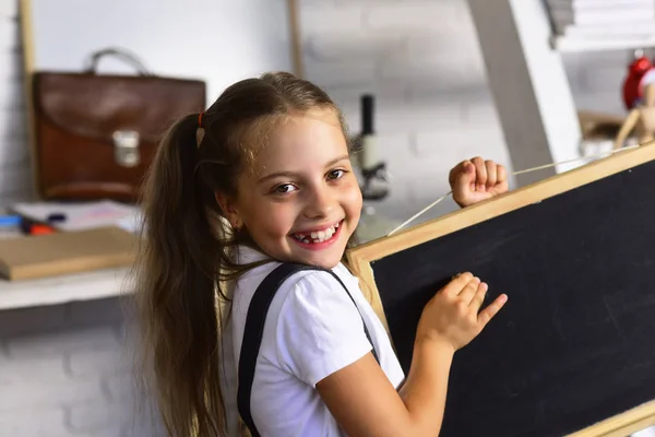 Flicka med leende ansikte uttryck nära skrivbord med skolmaterial — Stockfoto
