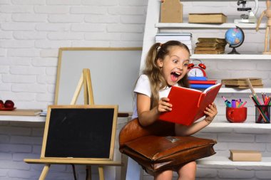 Öğrenci gülüyor ve kahverengi deri çanta tutar. Okula dönüş