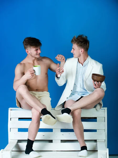 Män som ler på träbänk på blå bakgrund — Stockfoto