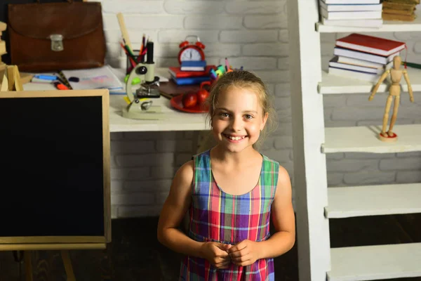 Girl with happy face expression in front of desk — Stock Photo, Image