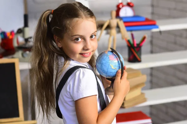 Kid studia geografia. Studentessa tiene piccolo globo modello — Foto Stock