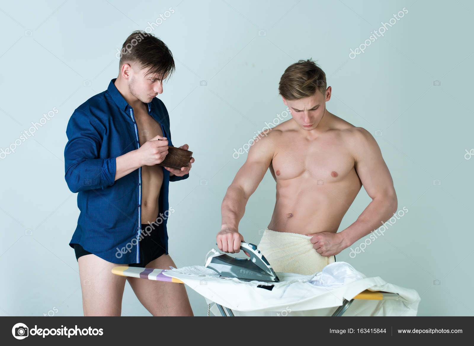 Man ironing clothes with iron on board - Stock Photo. 