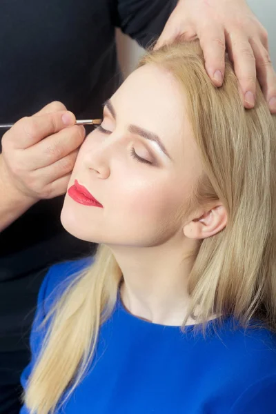 Chica consiguiendo maquillaje sombra de ojos por el hombre con cepillo — Foto de Stock