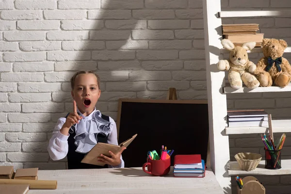Kız öğrenci yazı tahtası yakınındaki açık kitap fikri vardır