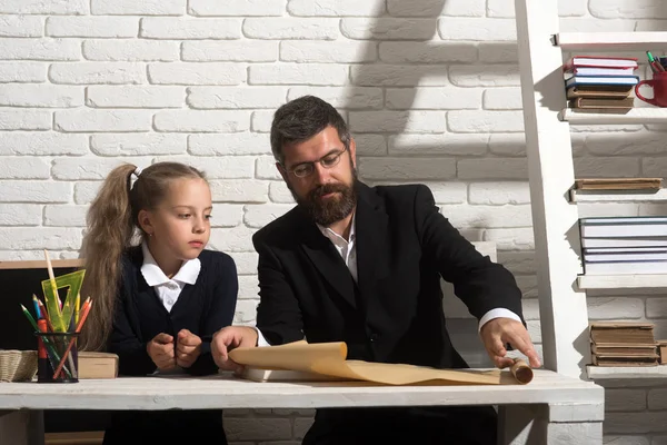 Девочка и отец в учебной комнате на фоне белого кирпича — стоковое фото