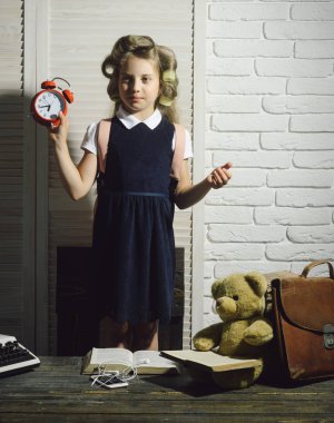 Evrak çantası ve çalar saat ile çocuk.