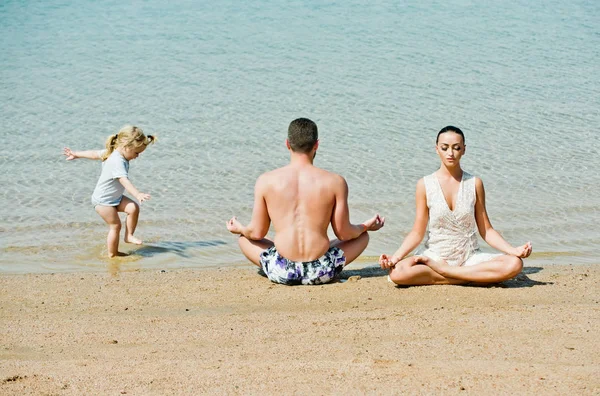 Pareja de hombre y mujer con niño meditando, pose de yoga —  Fotos de Stock