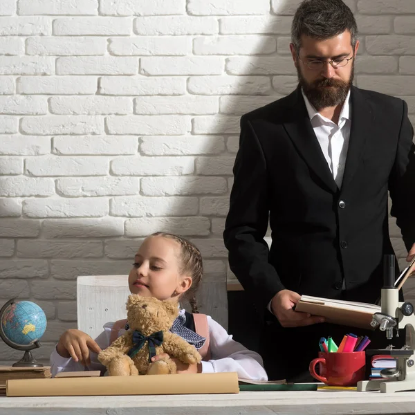 Školačka a dad zaneprázdněni tváří drží medvěda a knihy — Stock fotografie