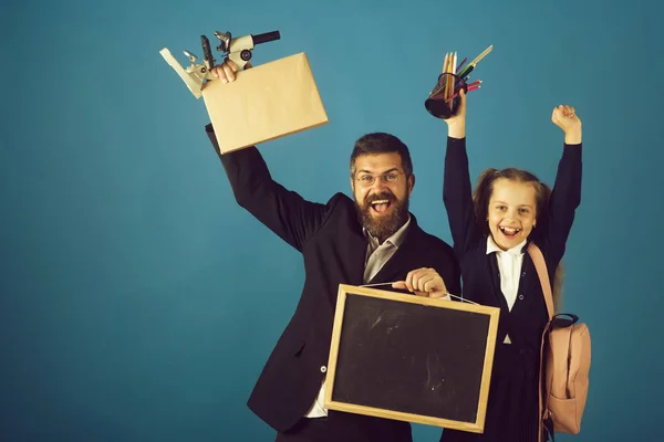 Kind und Lehrer halten Schulmaterial und Tafel in der Hand — Stockfoto