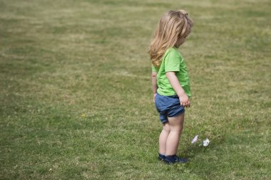 Uzun sarı saçlı beyaz çiçek görünümlü küçük çocuk
