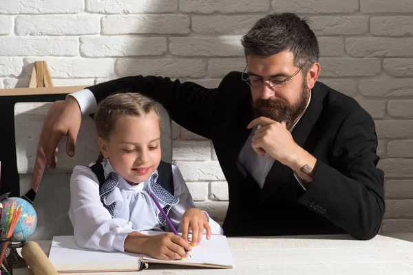 Familjen arbetar på skrivbord med skolmaterial. Flicka och far — Stockfoto