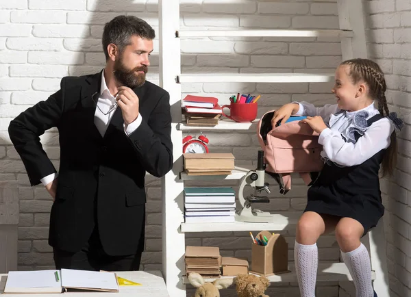 Aile okul malzemeleri ile raf yanında duruyor