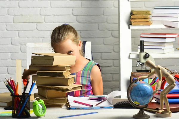 Çocuğun yanına bookshelf, ders kitapları ve okul malzemeleri