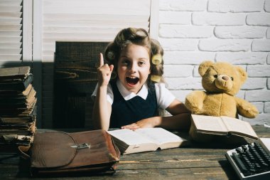 Küçük kız kıvırıcı saç ile kitap okumak.