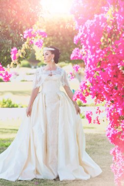 Pembe bush poz beyaz gelinlik içinde gelin.