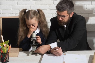 Kız ve erkek Resepsiyon tarafından oturup mikroskop bakmak