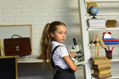 Çocuk deneyler yapar. Geri okul kavramı. Ponytails kızla