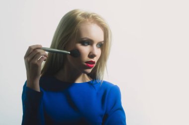 Kırmızı dudaklar ile fırça yüz makyaj uygulayarak kızla