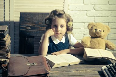 Evrak çantası ve masada daktilo ile çocuk.