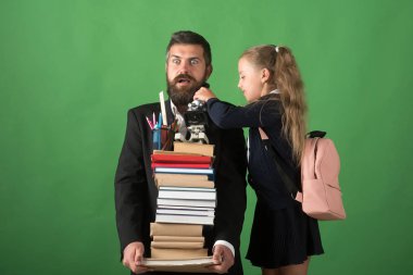 Çocuk ve öğretmen kitap yığın ve okul gereçleri