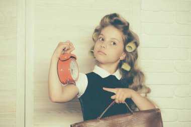 Evrak çantası ve çalar saat ile çocuk.