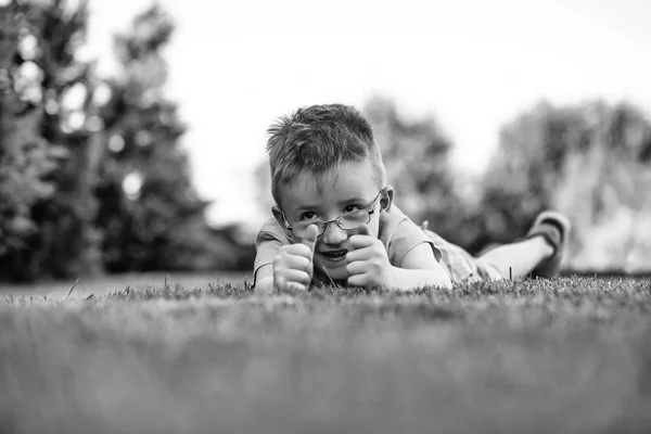 Chlapeček v brýlích na trávě — Stock fotografie