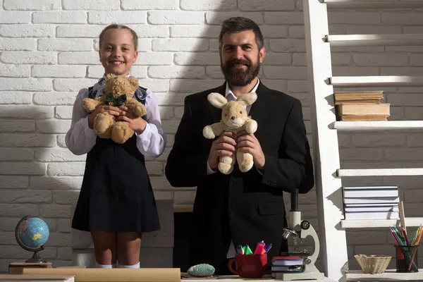 Kız öğrenci ve gülümseyen yüzler ile babası yumuşak oyuncaklar tutun
