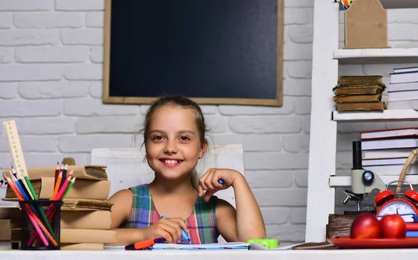 Mutlu yüz ile kız öğrenci sanat kitapta çizer