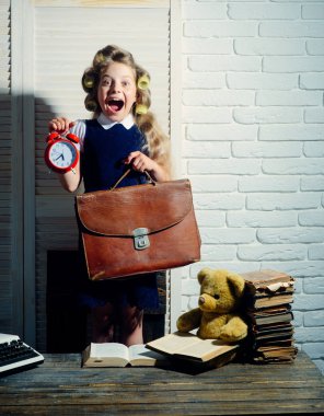 Evrak çantası ve çalar saat ile çocuk.